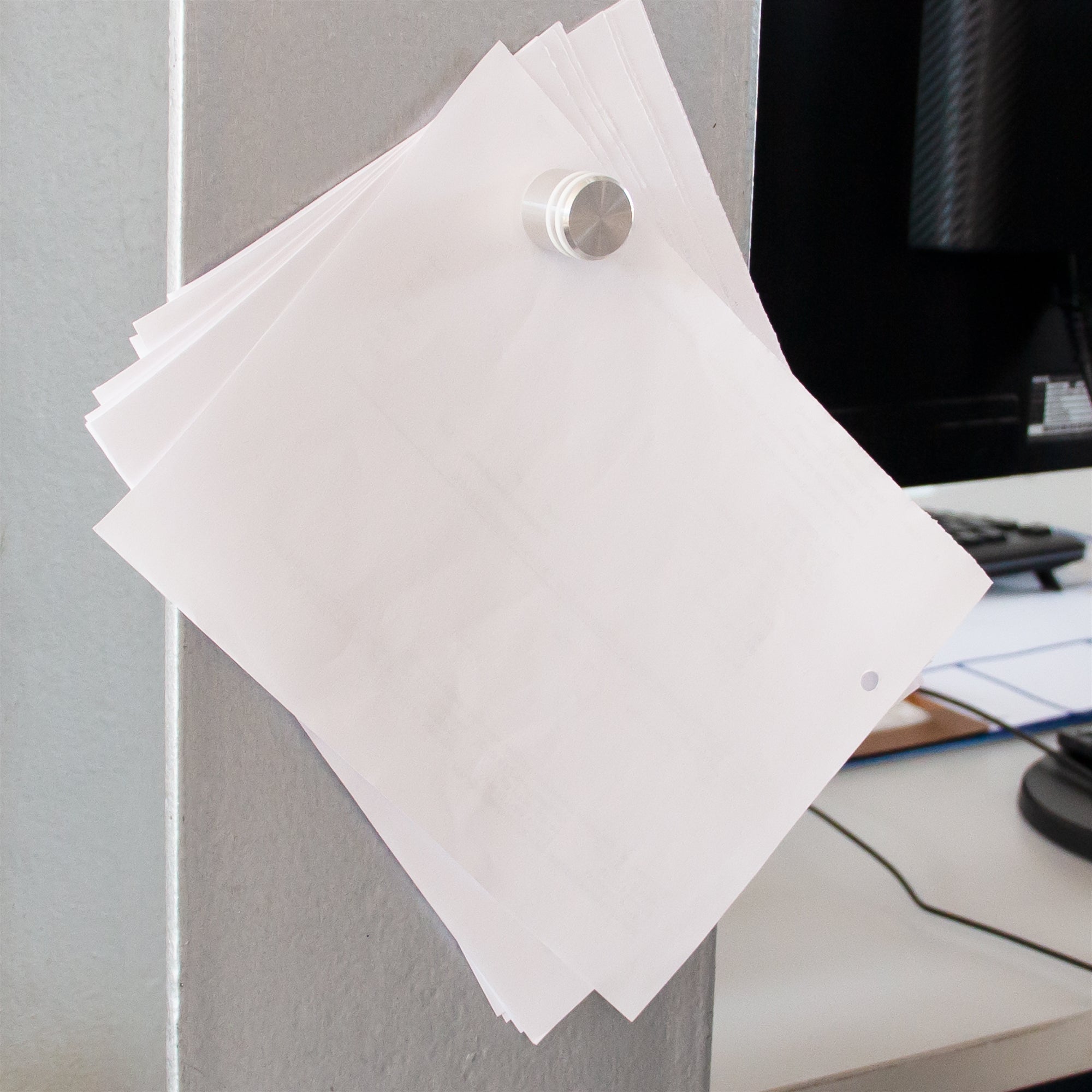 Griffiger Büromagnet hält einen stapel DIN A4 Blätter